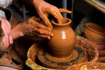 hands of a potter, creating an earthen jar