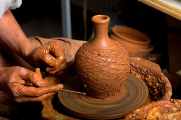 hands of a potter, creating an earthen jar