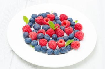Fresh raspberries and blueberries on a plate