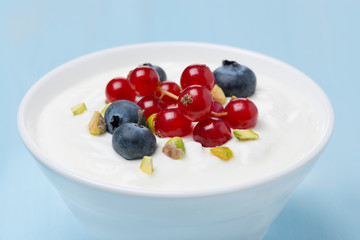 fresh sweet yogurt with berries and pistachios, close-up