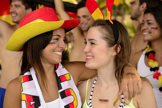 German girls friends soccer fans celebrating.