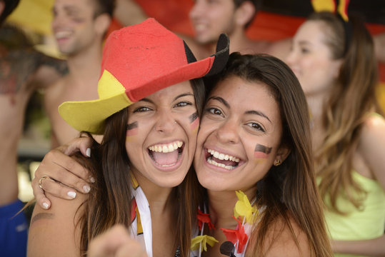 Happy couple of girlfriends sport soccer fans celebrating.