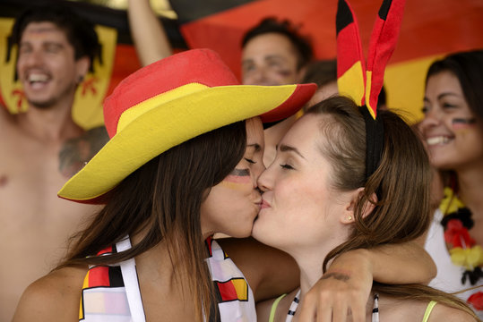 German soccer fans kissing each other celebrating.