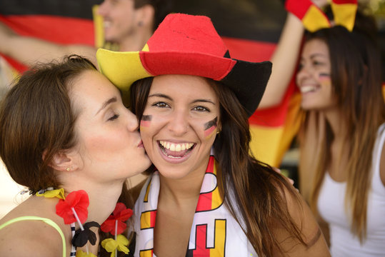 German couple of soccer sport fans kissing celebrating.