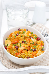 pilaf with vegetables, chicken and pomegranate in a bowl