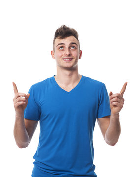 Young man pointing at empty copy space above him