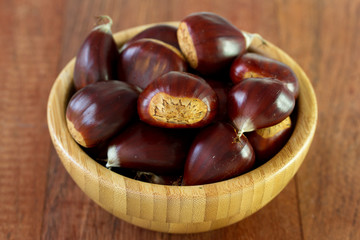 chestnuts in bowl on brown background