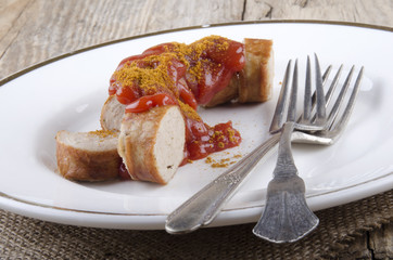 curried sausage with ketchup on a plate