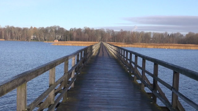 long empty wooden bridge on autumn lake