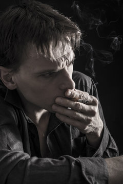 Close up of depressed man smoking cigarette