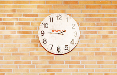 Fototapeta na wymiar An old station clock over bricks wall
