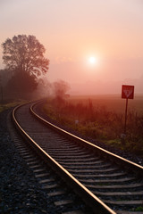 Fototapeta na wymiar Tory kolejowe jesienią mglisty poranek
