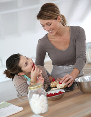 Mother and daughter preparing cream puffs