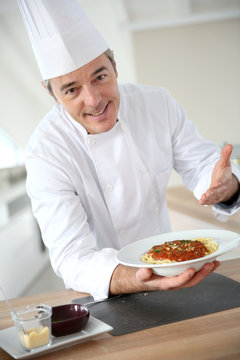 Chef in kitchen presenting italian dish