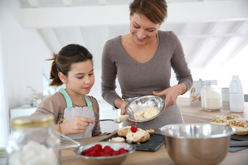 Mother and daughter preparing cream puffs