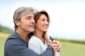 Portrait of smiling middle-aged couple in countryside