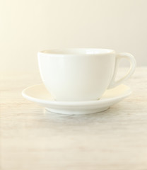Obraz na płótnie Canvas A white teacup on a wooden table