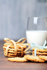 Some cookies with ribbons and a glass of milk