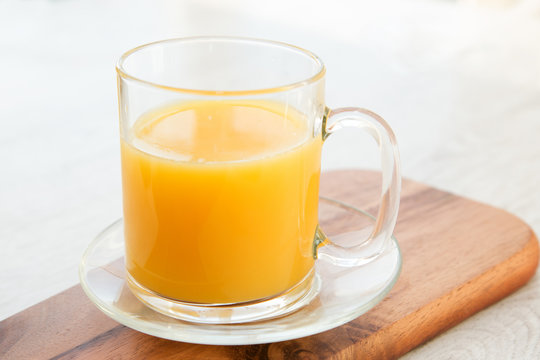 A cup of juice on a wooden board