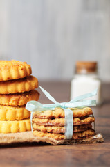 Some cookies with a ribbon on linen and wood
