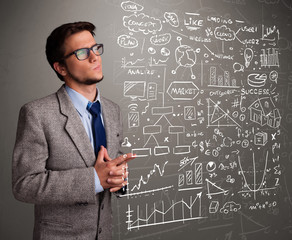 Attractive man looking at stock market graphs and symbols