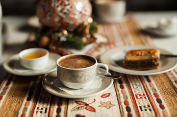 A cup of coffee with honey and baklava