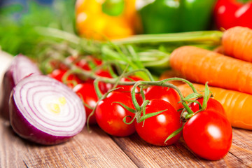 Carrot, tomato and paprika on a wooden table
