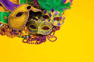 group of Mardi Gras or venetian mask sor costumes on a yellow