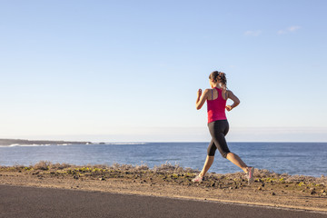 Young woman jogging along the seacoast