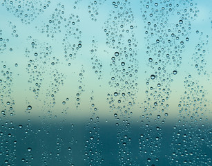 Naklejka na ściany i meble Raindrops on window of a ship at sea with horizon