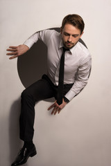 Naklejka premium Businessman climbing out of a circular hole