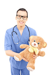 Male healthcare professional in uniform holding a teddy bear