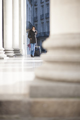 young woman with a suitcase walking in the street