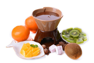 Chocolate fondue with sliced fruits, isolated on white