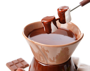 Chocolate fondue with marshmallow candies, isolated on white