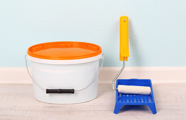 Paint and roll on floor in room on wall background