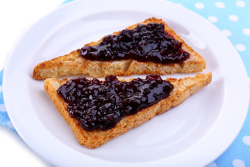 Delicious toast with jam on plate close-up
