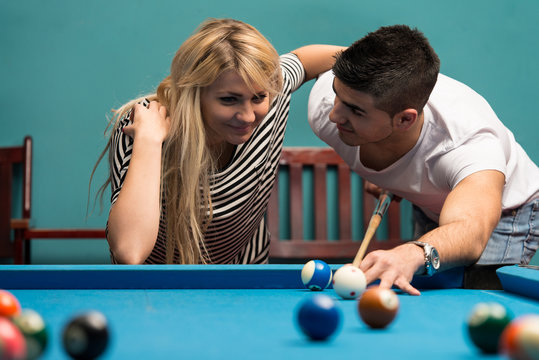 Couple Playing Pool At The Bar