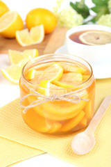 Tasty lemon jam with cup of tea on table close-up