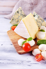 Different tasty cheese, on wooden table