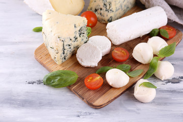 Different tasty cheese, on wooden table