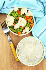 Cooked rice with vegetables on wooden table