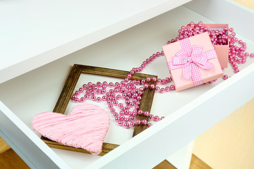 Gift box and beads in open desk drawer close up