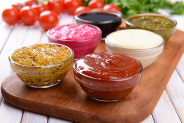 Various sauces on chopping board on table close-up