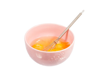 eggs in a pink bowl with the whisk