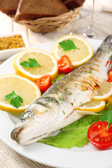 Delicious grilled fish on plate on table close-up