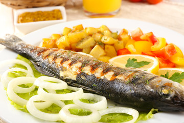Delicious grilled fish on plate on table close-up