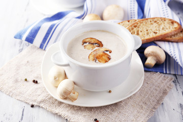 Mushroom soup in white pots, on napkin,  on wooden background