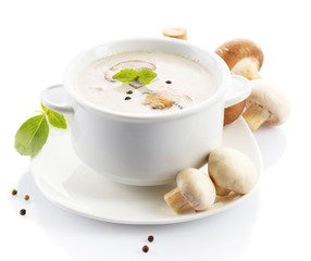 Mushroom soup in white bowl, on plate, isolated on white