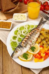Delicious grilled fish on plate on table close-up